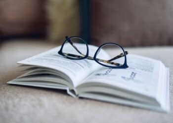 Soft focus glasses, book on the sofa. Abstract book blur background. Concept for education.